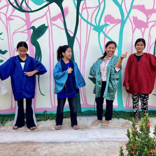 Capes portées par Lestari et les jeunes filles du cours d'anglais, et détails de peinture murale